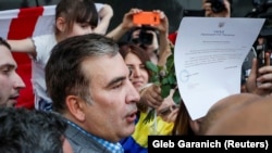 Михаил Саакашвили демонстрирует в Киевском аэропорту приказ президента Украины о возвращении гражданства