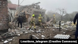 Emergency crews work at a site following a Russian air attack on the Ukrainian city of Rivne on October 14.