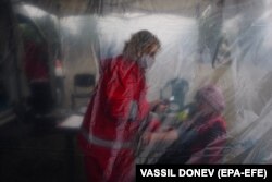 A women receives a medical examination before getting a vaccine against COVID-19 from a mobile immunization team in the Bulgarian village of Krushovitsa.