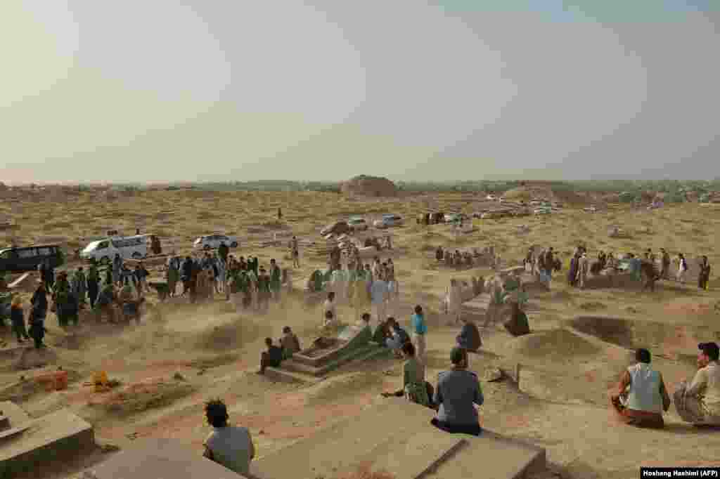 Relatives and friends stand next to the graves of victims of a suicide bomb attack on worshippers at a Shi&#39;ite mosque in the northern Afghan province of Kunduz, which killed dozens of people on October 8.&nbsp;