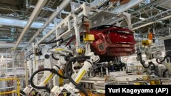 Robotkarok helyezik be az elektromos jármű hajtásláncát az Ariya modellbe a Nissan Tocsigi üzemének összeszerelősorán a japán Tocsigi prefektúra Kaminokava városában 2021. október 8-án