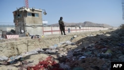 A Taliban fighter stands guard at the site of the August 26 attack, which killed scores of people including 13 U.S. troops, at Kabul airport.