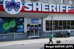 A man pushes a shopping cart in front of a Sheriff supermarket in Tiraspol. (file photo)