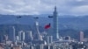 Egy katonai helikopter tajvani zászlót reptet körbe Tajpejben 2021. október 7-én