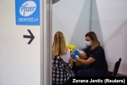 A Pfizer–BioNTech-vakcina harmadik dózisát adják be egy nőnek a belgrádi vásár telephelyén rendezett oltási központban Belgrádban, 2021. augusztus 25-én