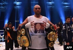 Тайсън Фюри позира с шампионските пояси във версии WBA, IBF, WBO и IBO след победата си срещу Владимир Кличко в Дюселдорф, 28 ноември 2015 г.