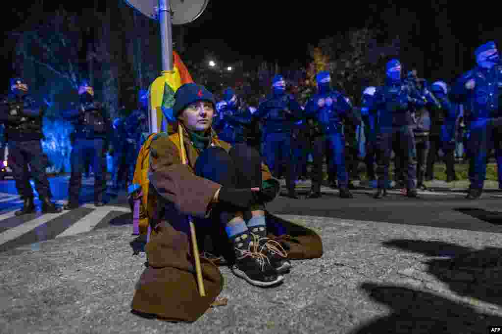 Протестиращ седи пред централата на партията &quot;Право и справедливост&quot; по време на протеста във Варшава.
