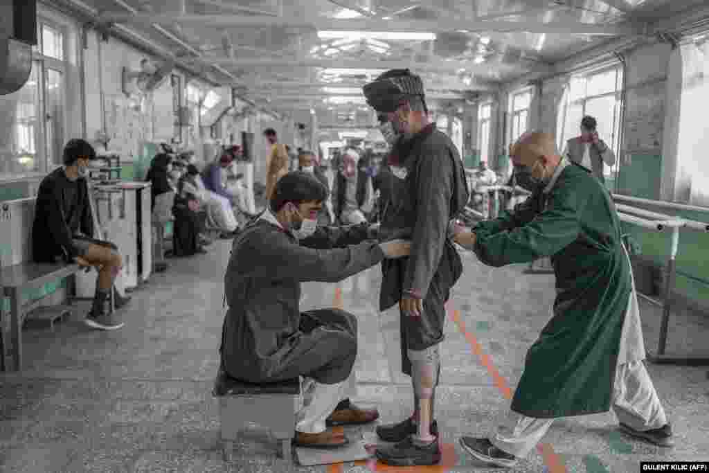 Members of the Red Cross help a Taliban member who claims to have lost a leg earlier in a U.S. air strike.&nbsp;