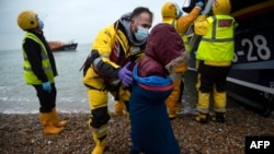 Pomaganje migrantima na plaži u Dungenessu, na jugoistočnoj obali Velike Britanije, 24. novembra 2021., nakon što su spašeni dok su prelazili Lamanš.
