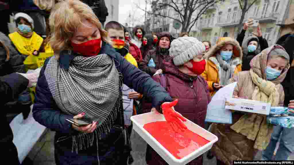 Учасниці акції символічно нанесли руками &laquo;сліди крові&raquo; на двері 