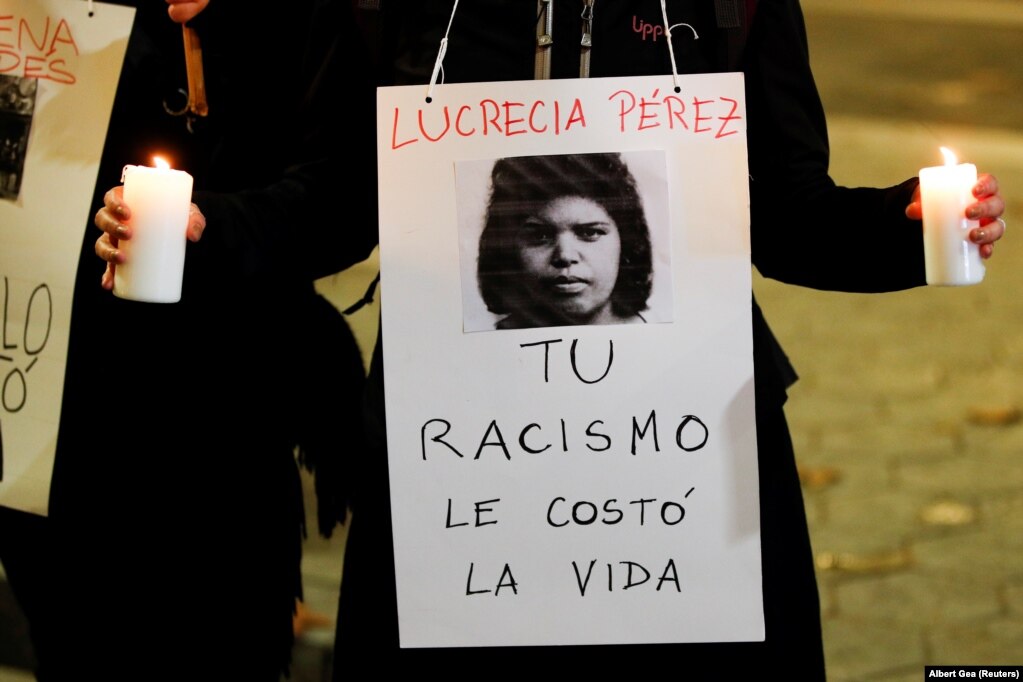 Një person duke mbajtur një shenjë me mbishkrimin "Racizmi juaj i kushtoi asaj me jetë", gjatë një proteste, në Barcelonë, Spanjë.