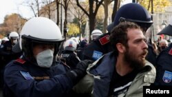 Një demonstrues arrestohet nga oficerët e policisë gjatë një proteste kundër masave ndaj COVID-19 në Vjenë, Austri, 20 nëntor 2021. 