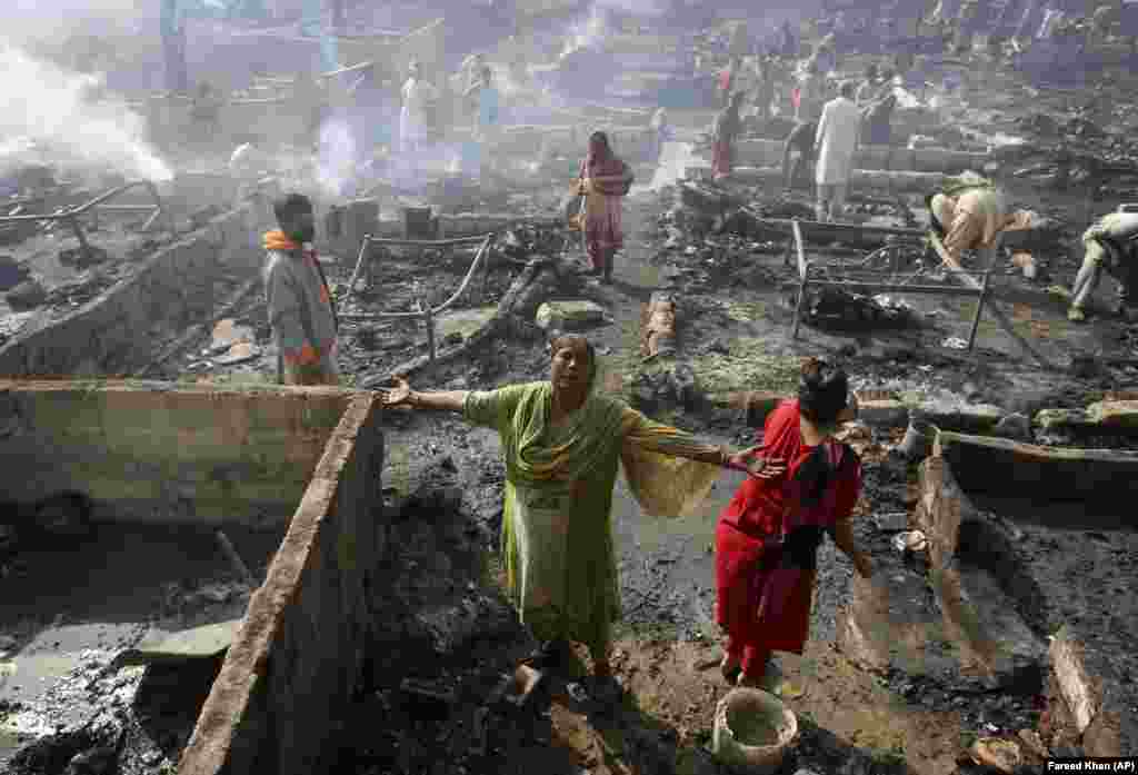A woman grieves while she and others collect their belongings in a slum in Karachi, Pakistan, following a fire that gutted many dwellings and made dozens of families homeless.&nbsp;