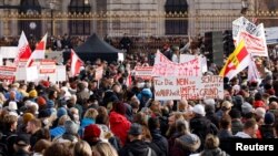 Na protestu protiv novih najavljenih COVID mjera u Beču demonstranti drže zastave i plakat na kojem piše: "Za istinu, ne obaveznoj vakcinaciji, zaštitite naša prava", 20. novembra 2021. 