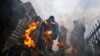 Bosanskohercegovački rudari griju se uz vatru dok protestuju protiv mjera usmjerenih na transformaciju njihove industrije ispred zgrade Vlade Federaije BiH u Sarajevu 23. novembar 2021.