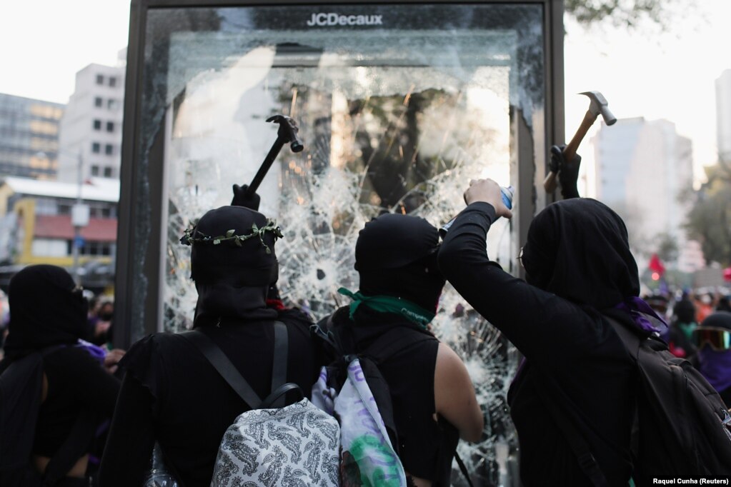 Disa demonstrues duke thyer një reklamë, gjatë një proteste, në Meksiko Siti, Meksikë.