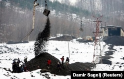 People sort through a pile of scrap coal dumped from a mine near Banovici. The locals are looking for chunks of coal they can use or sell.