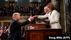 Președintele Donald Trump dă mâna cu Nancy Pelosi, înainte să-și rostească discursul anual în Congres, 5 februarie 2019