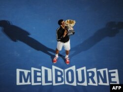 Novak Đoković ljubi trofej osvojen na turniru u Melburnu, 29. januar 2012.