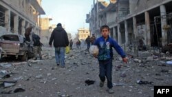 A Syrian boy runs while carrying bread following a reported airstrike by government forces in the town of Idlib, a major jihadist stronghold in northwestern Syria. 