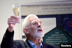 Клаус Хассельман поднимает бокал шампанского на встрече с коллегами и журналистами после объявления его лауреатом Нобелевской премии, 5 октября 2021 года. Фото: Reuters