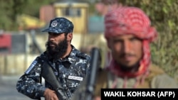 Taliban fighters man a checkpoint outside Kabul on October 3.