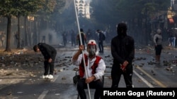 Një burrë me veshje tradicionale shqiptare qëndron ulur në mes të një rruge gjatë protestës antiqeveritare nga studentët në Tiranë, Shqipëri, më 14 tetor 2026.