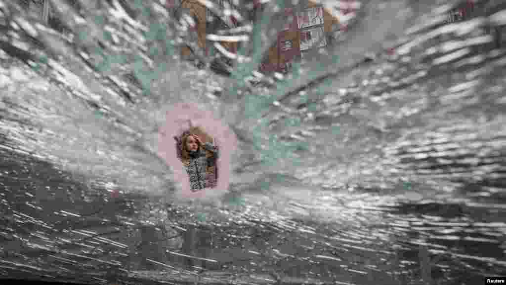 Kosovë: Një burrë duke shikuar një dritare të thyer në Prishtinë më 13 prill 1999, pas sulmeve ajrore të NATO-s mbi caqet serbe në kryeqytetin e Kosovës.Ukrainë: Një grua mund të shihet përmes një çarjeje në xhamin e një makine, e cila u godit nga raketat ruse pranë një blloku apartamentesh në Kiev.