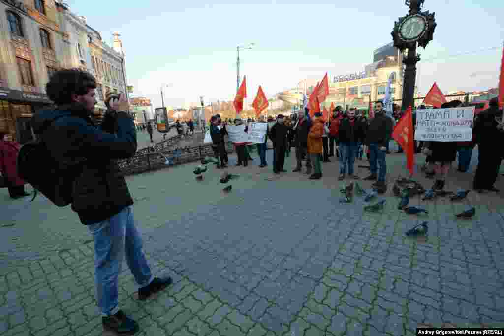 Иностранная молодежь позирует на фоне плакатов и красных флагов &nbsp;