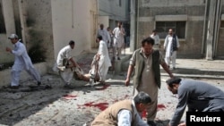 Men remove dead bodies from the site of the suicide bomb attack inside a civil hospital in Quetta on April 16.