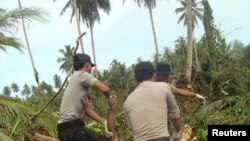 Police carry a recovered body in the Muntei Baru Baru village on Indonesia's Mentawai islands 