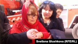 Багжан Аязбекова (в центре) после того, как ее спустили на землю с высотного крана. Ее акция протеста против приговора ее сыну Азамату. Астана длилась тогда семь дней. 4 июня 2013 года.