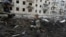 Police officers inspect a crater in front of a damaged residential building hit by a Russian strike in Kharkiv on March 27.