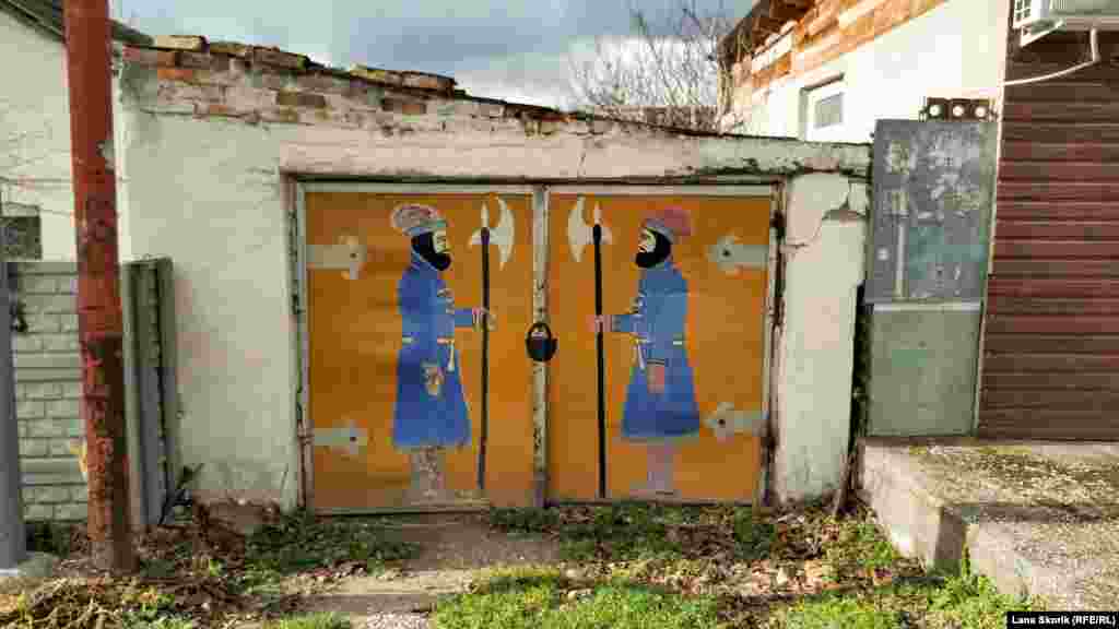 Ворота гаража частного дома на улице Студенческой в Терновке охраняют сказочные стражники