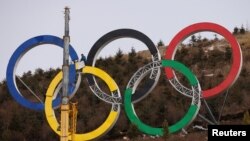 Рабочие собирают олимпийские кольца на лыжной площадке зимних Олимпийских игр в Пекине 2022 года в Чжанцзякоу, провинция Хэбэй, Китай, 20 ноября 2021 года