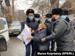 Kazakh police detain a woman holding a picket outside Beijng's consulate in Almaty calling for the release of relatives in the Chinese province of Xinjiang on November 8.