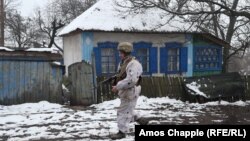 A Ukrainian soldier walks past an abandoned house at the front line near Zolote in Ukraine's Luhansk region on December 7.