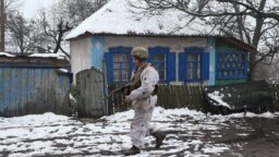 A Ukrainian soldier walks past an abandoned house at the front line near Zolote in Ukraine's Luhansk region on December 7.