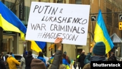 پوستری با این مضمون که «پوتین و لوکاشنکو جنایتکار جنگی هستند»