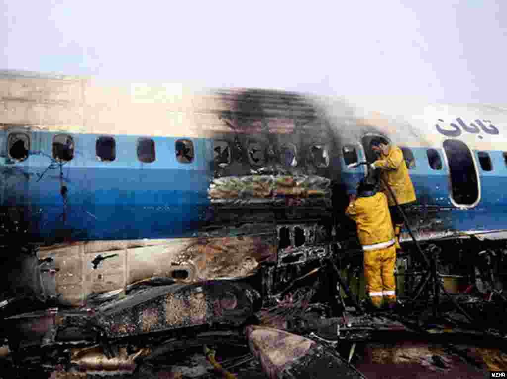 Workers inspect a plane that crash-landed at Mashhad Airport in northeastern Iran on January 24. - At least 46 people were injured when the Taban Air plane caught fire shortly before landing. Photo by MEHR