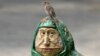 O pasăre pe capul sculpturii decorative "Bătrână pe o bancă", într-un parc din Kiev. 