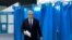 Kazakh President Qasym-Zhomart Toqaev walks out of a voting booth before casting his ballot in Astana on November 20.