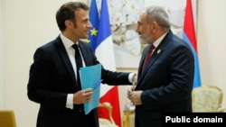 French President Emmanuel Macron (left) and Armenian Prime Minister Nikol Pashinian talk in Djerba, Tunisia., on November 19.