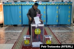 Мужчина с внучкой голосует в день выборов президента Казахстана. Алматы, 20 ноября 2022 года