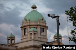 O cameră de supraveghere este văzută în fața clădirii parlamentului sârb din Belgrad.