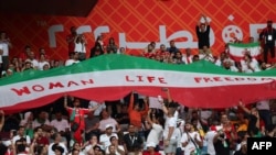 Иранские болельщики на чемпионате мира с лозунгом в поддержку протестующих в Иране