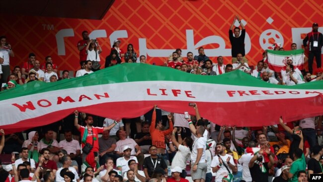 هواداران ایرانی فوتبال همزمان با بازی تیم‌های ایران و انگلیس پرچمی را با شعار «زن، زندگی، آزادی» به اهتزاز در آوردند.