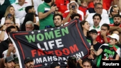 Iráni szurkolók az Anglia–Irán-mérkőzésen Katarban „Nők – Élet – Szabadság” felirattal 2022. november 21-én