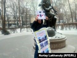 An Almaty resident holds a banner in support of ethnic Kazakhs in Xinjiang on December 9, 2022.