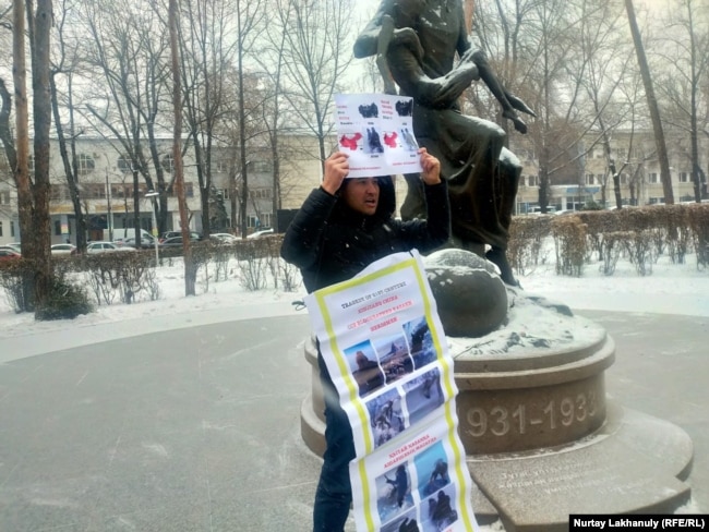 An Almaty resident holds a banner in support of ethnic Kazakhs in Xinjiang on December 9, 2022.